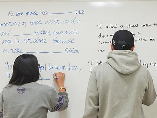 Students writing on the whiteboard