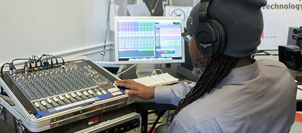Faculty using equipment in the Music Recording Room