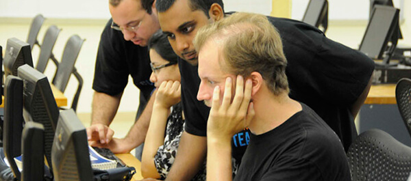 Faculty helping students using the computer