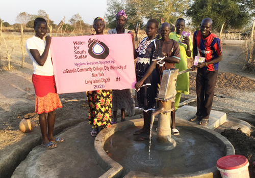 group of people standing next to a well