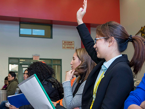 Student raising hand in lecture