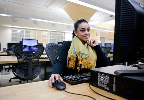 Student in front of a computer in the Computer Lab Room