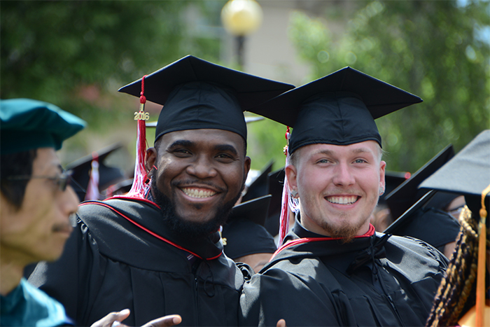 two students with cap-and-gowns at commencement