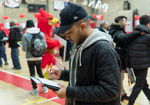 Student filling up information sheet at job fair
