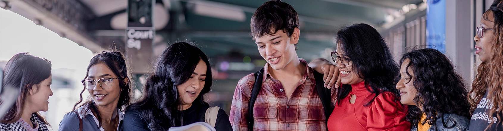 Six diverse students smile happily in a group, reflecting the inclusive and positive atmosphere at LaGuardia, where they are applying.