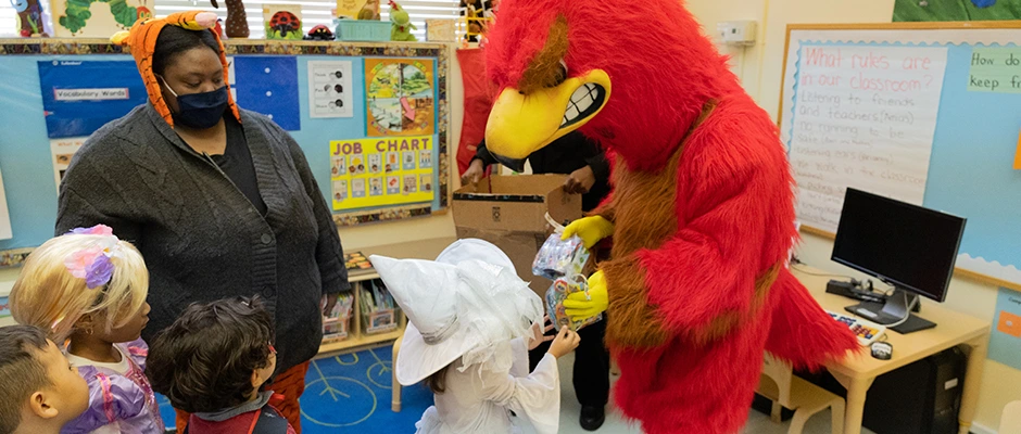 Rebel Mascot giving out treats to kids