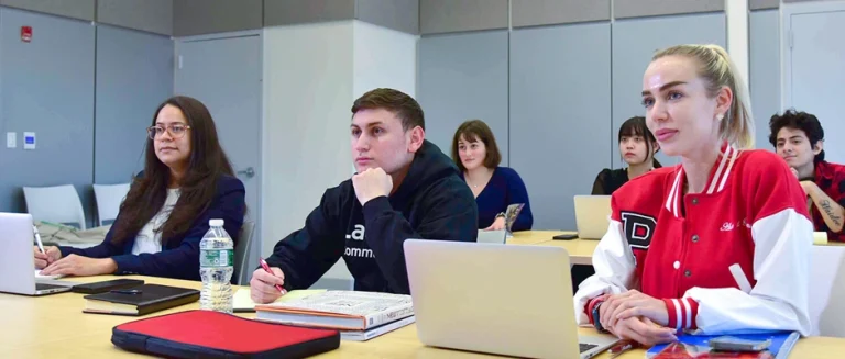 Students seating in a classroom listening to the teacher