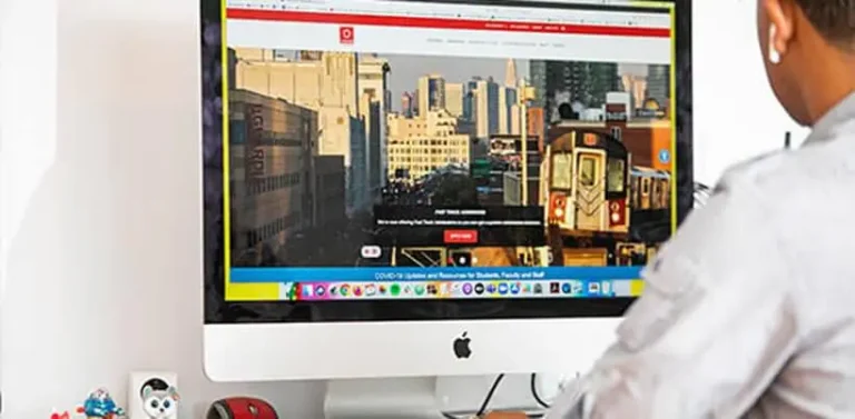 Guy in front of a computer exploring LaGuardia website