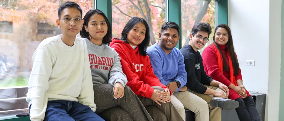 Students in the E-Building Atrium sitting by the window
